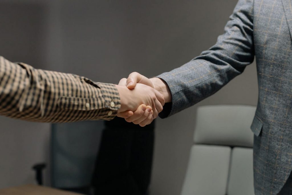 Your People Are Your Best Marketing - Two people shaking hands showing interactions between team member and client.