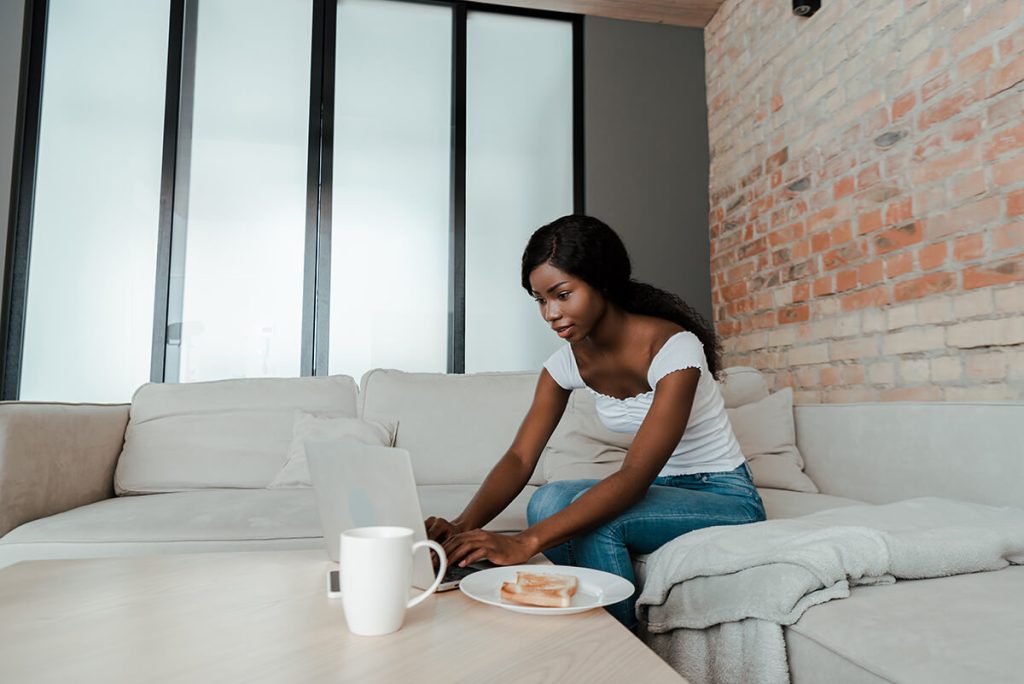 Young woman writing blog on laptop